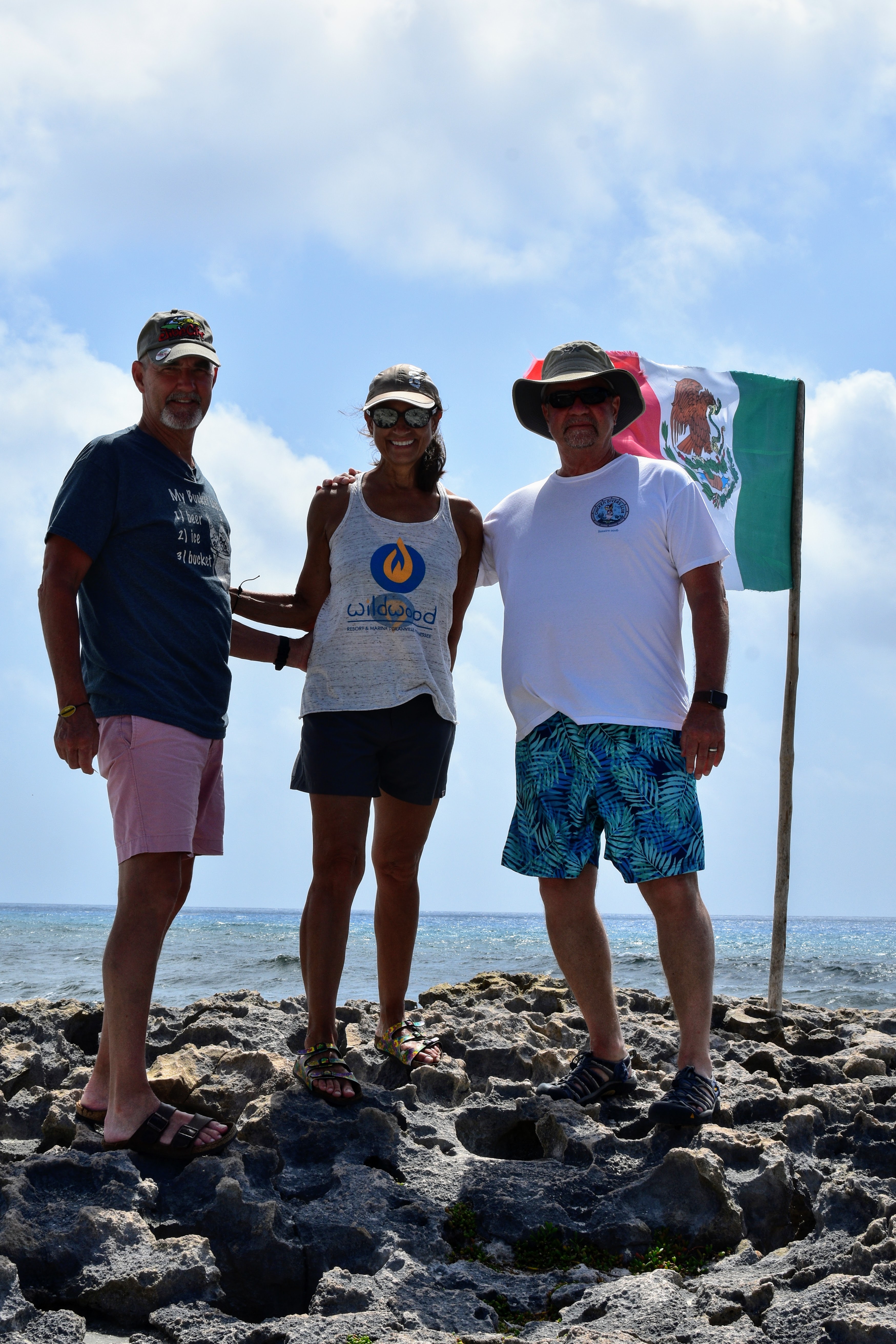 men and woman standing by Mexican flag