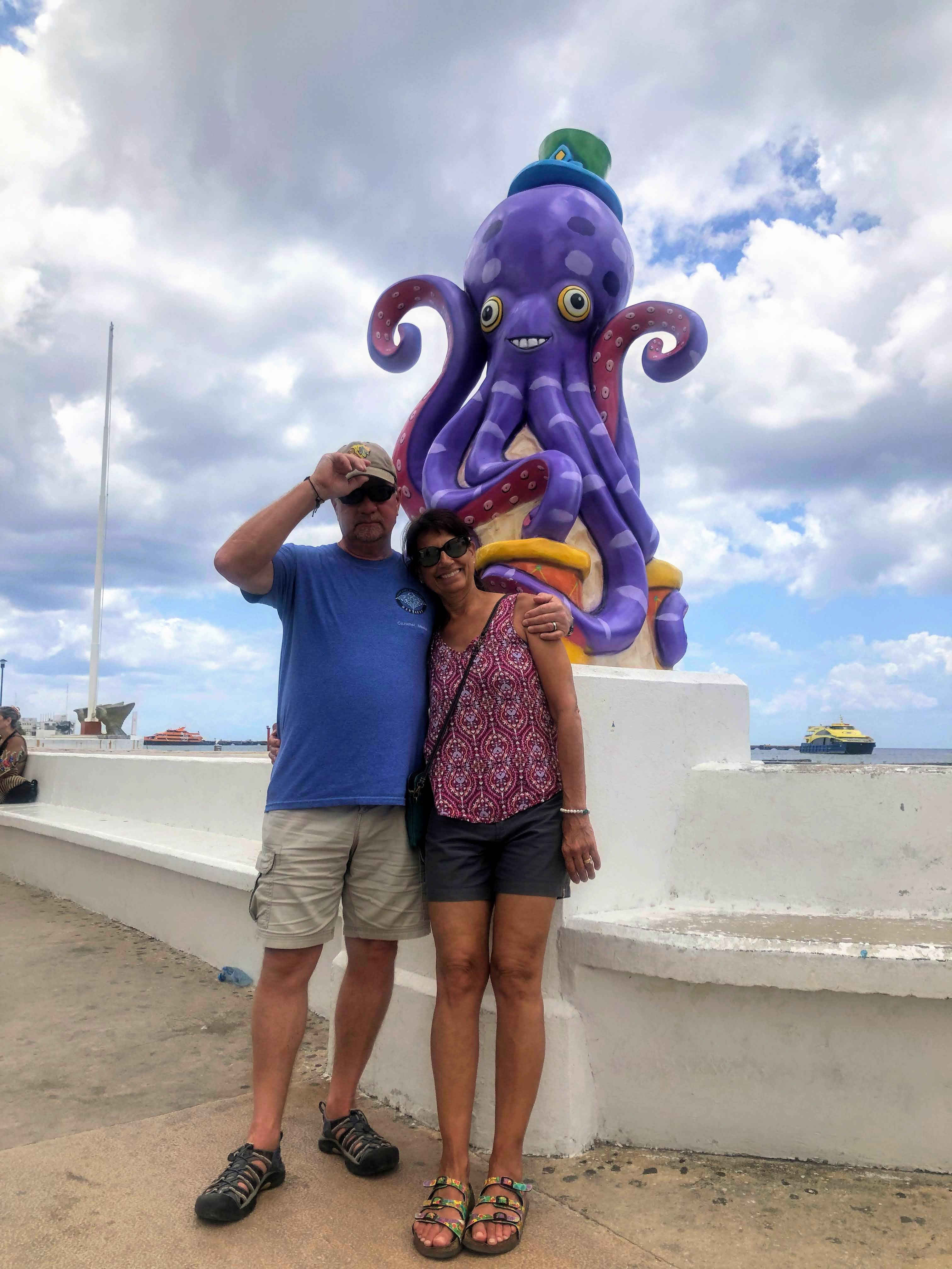 man and woman standing by octopus statue